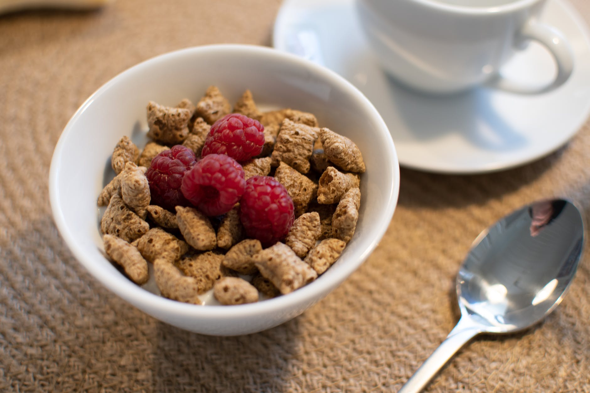 bowl of cereals with raspberries